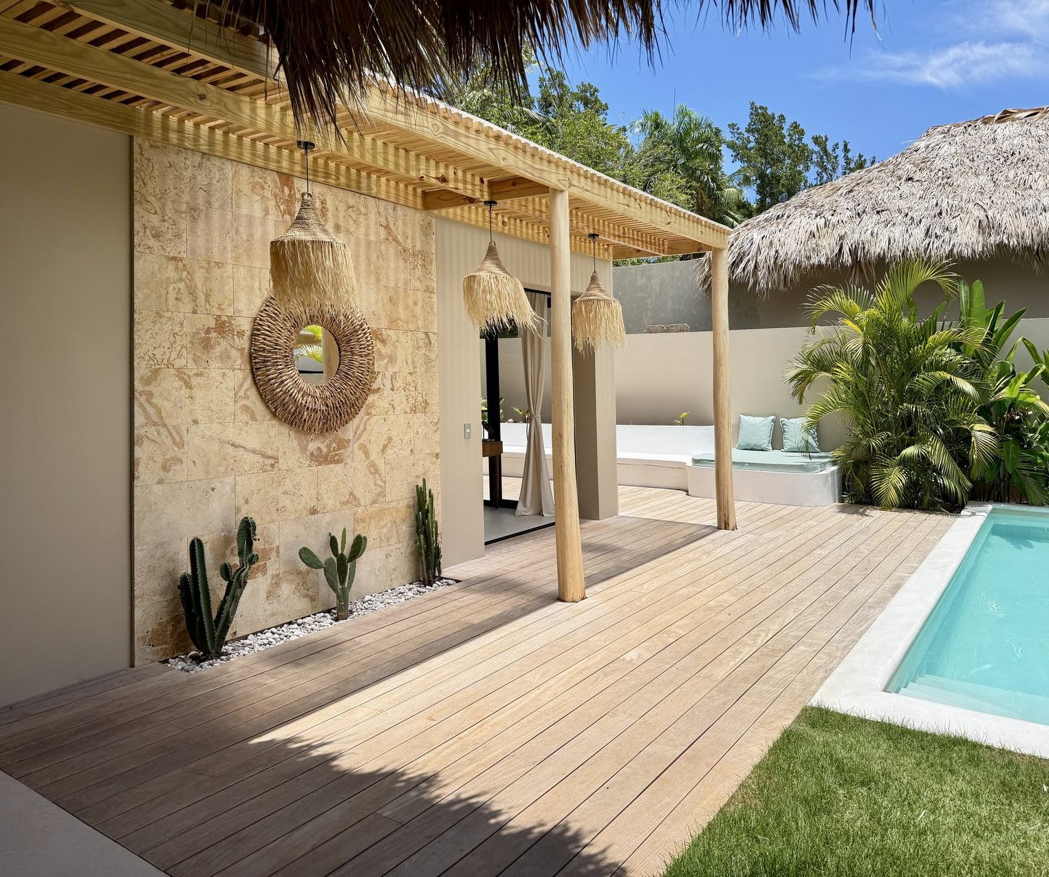 La terrasse de bois sous la pergola, le mur de travertin et le coin des cactus — Villas Origen