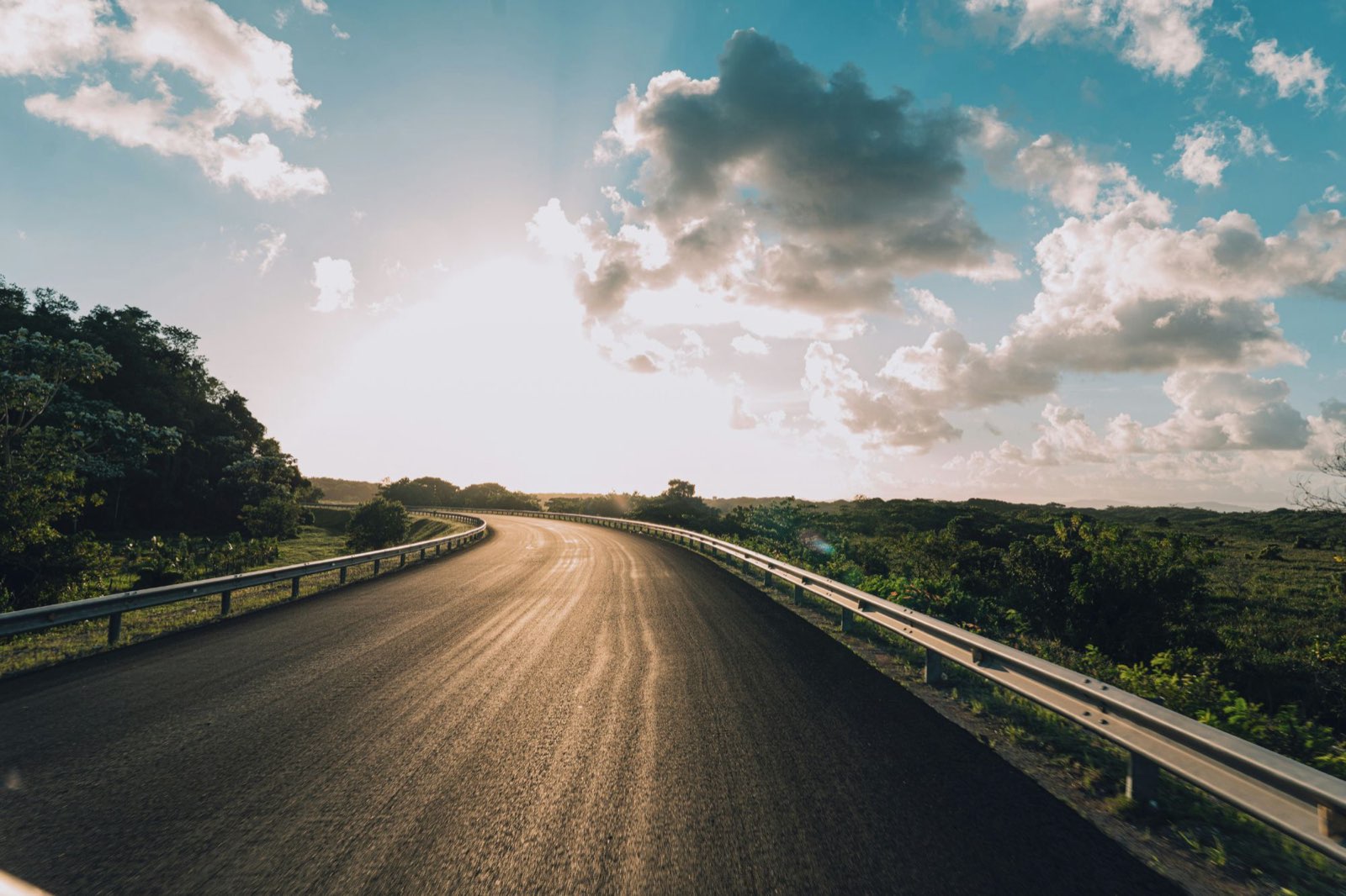 Une route asphaltée bordée de glissières, sous un grand ciel, dans la péninsule de Samaná